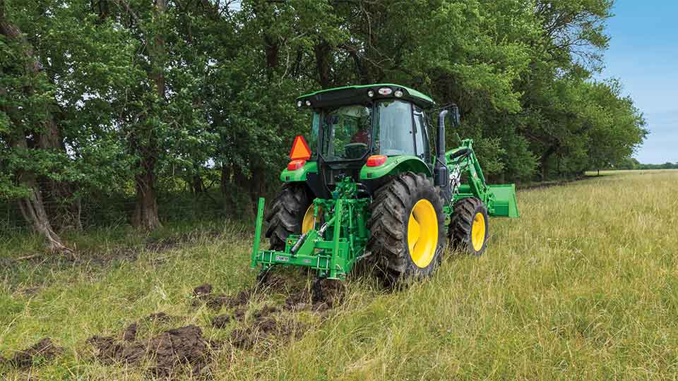 compact utility tractor with trencher in use