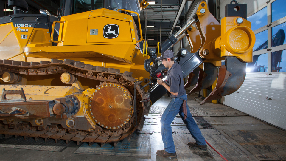 technician at burnsville inspecting a john deere 1050k