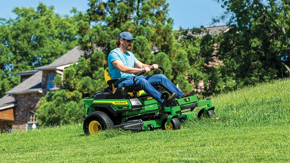 person using zero-turn mower on grass