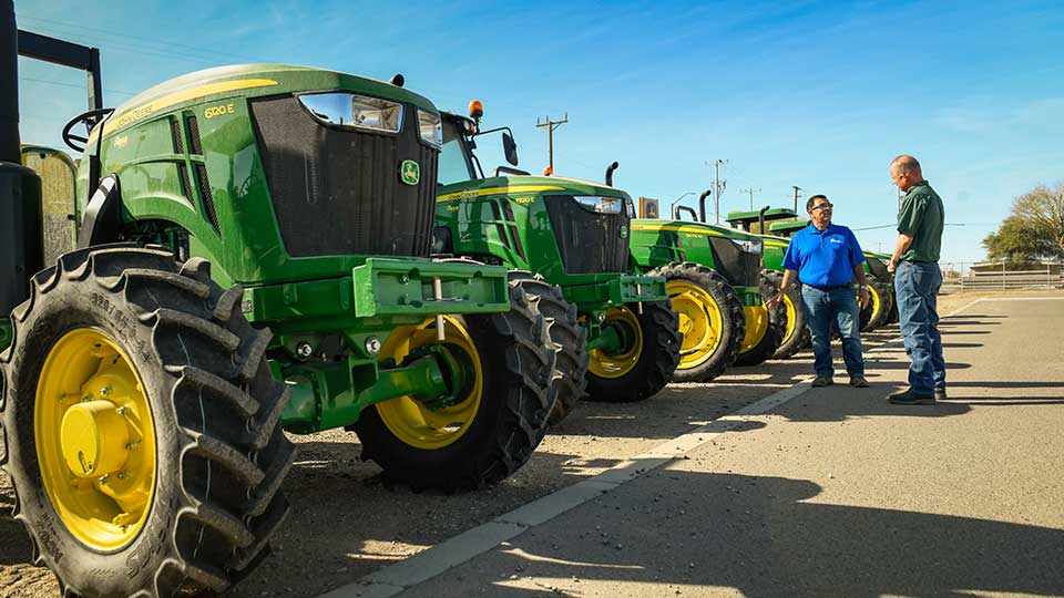 Sales Person in Yard Showing tractors to customer