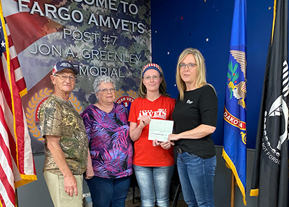 Hollie Ibach, RDO Equipment Co. Accounts Payable team member presents AMVETS VFW Post #7 members with a Community Builder Grant from the Offutt Family Foundation. 