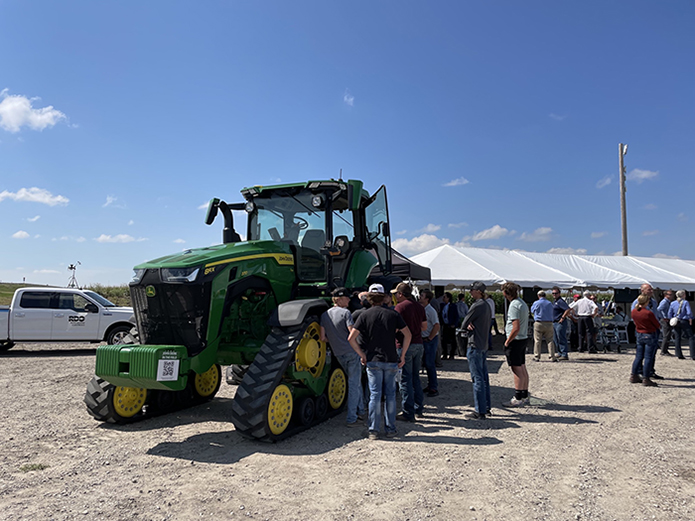 Conference attendees admire John Deere's 8RX Tractor. 
