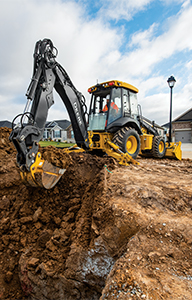 Backhoe digging in residential area.