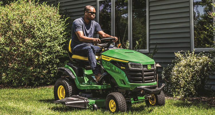 John Deere S240 lawn tractor mowing a lawn.