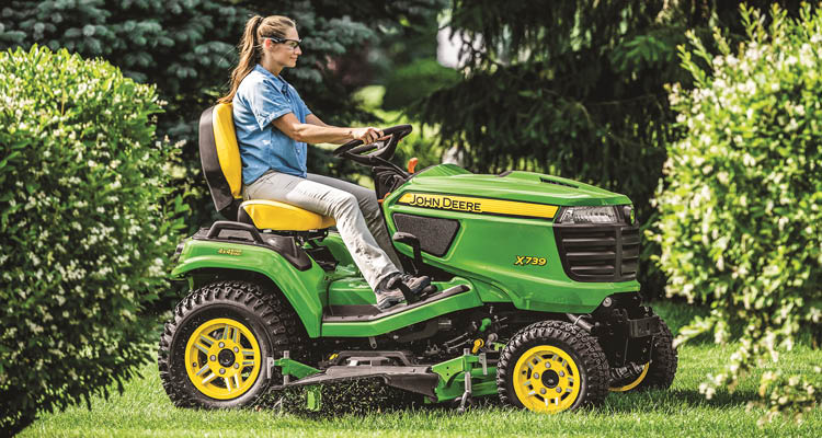 John Deere Signature Series X739 lawn tractor mowing a lawn.