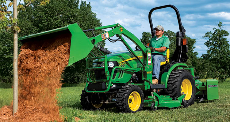 John Deere 2025r Compact Tractor Dumping Mulch Onto A Small Tree