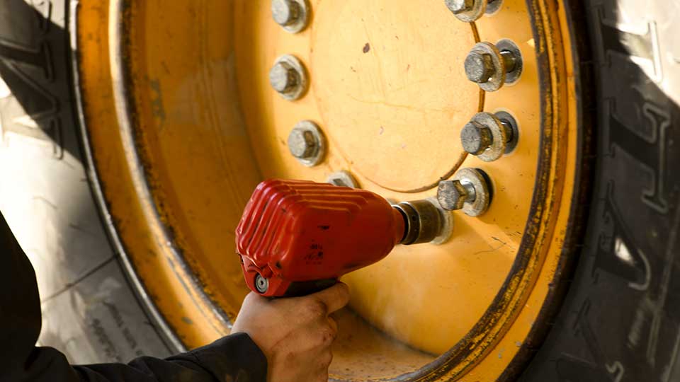 mechanic using drill on tire