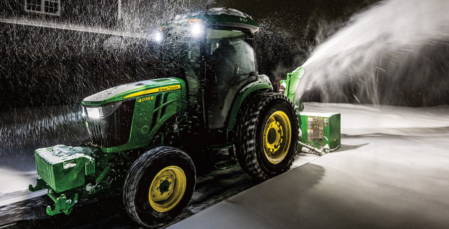 John Deere compact tractor with snow attachments.