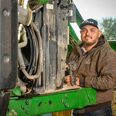 technician working on john deere tractor in field