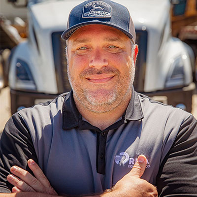 trucking manager in front of peterbuilt truck smiling