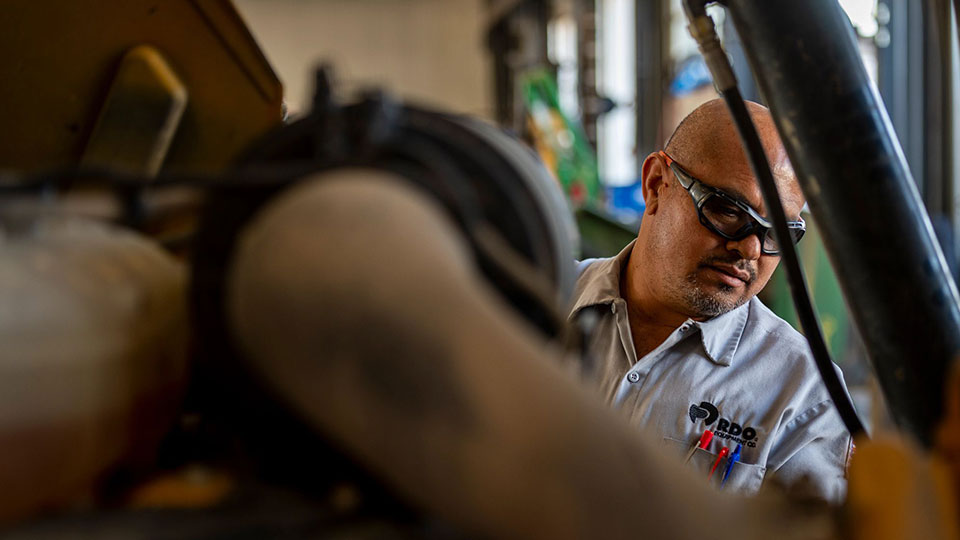 service technician examining john deere construction machine