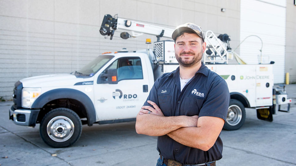 service technician in front of service vehicle at dealership