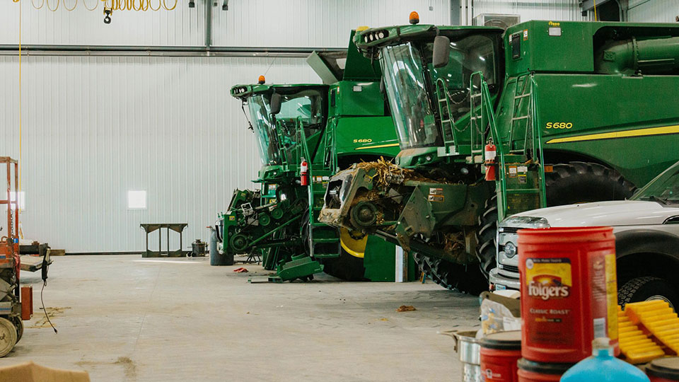 John Deere combines lined up in service shop