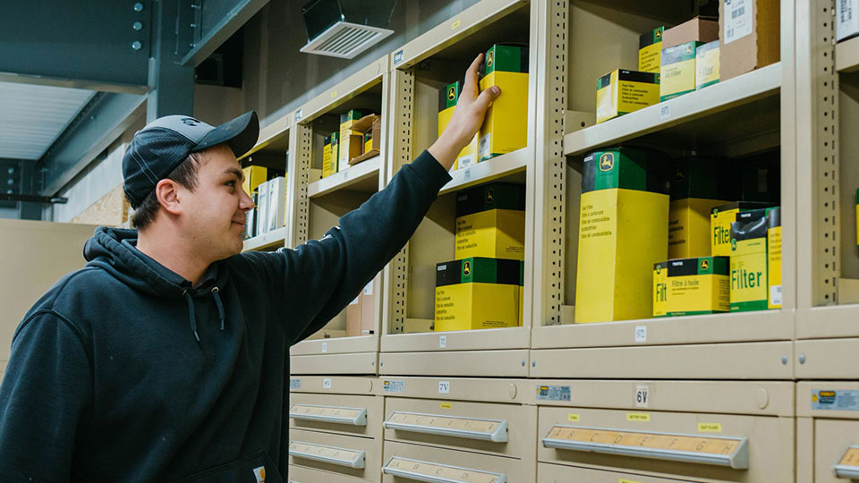 parts person grabbing parts from warehouse shelf