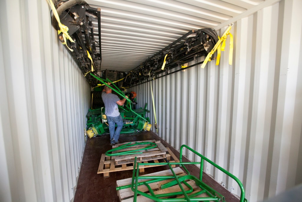 John Deere Self Propelled Sprayer being moved into a shipping container