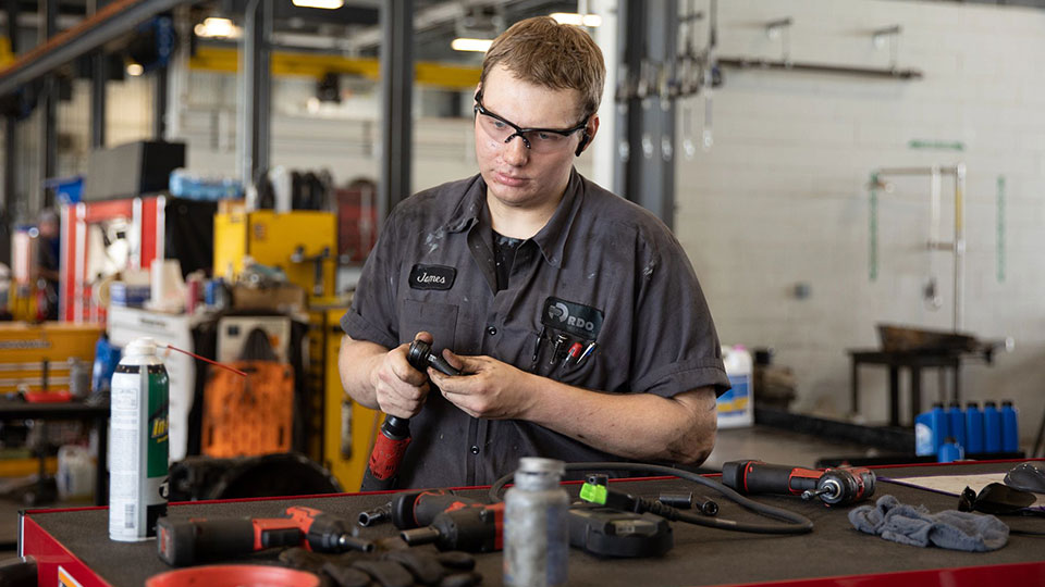 diesel mechanic working with tools on workbench