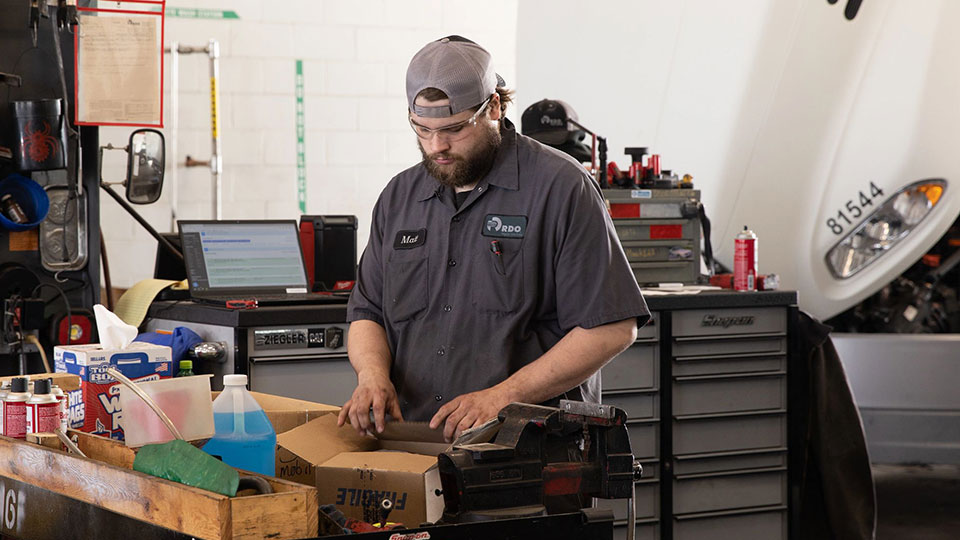 Service Mechanic unpacking boxes in service shop