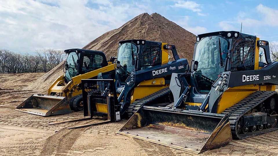 3 John Deere skid steers with loader attachments