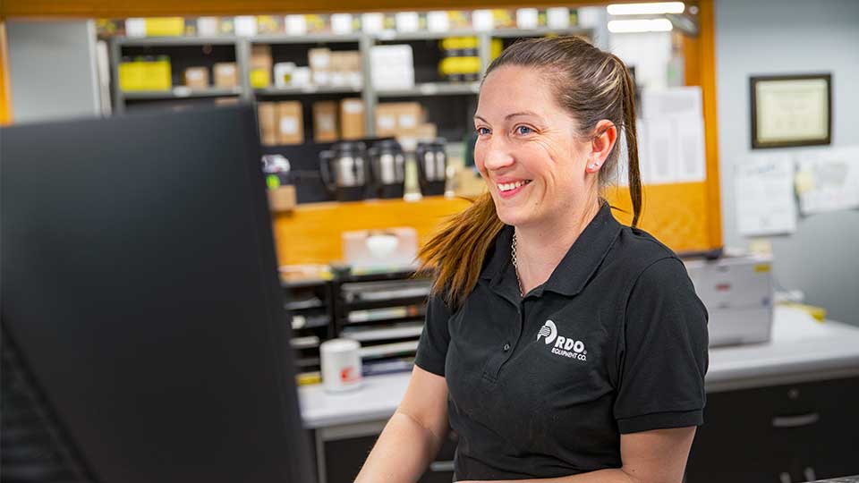 RDO parts specialist smiling behind parts counter at dealership