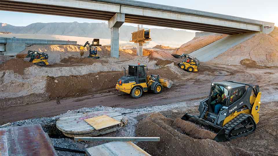 compact construction equipment jobsite under bridge