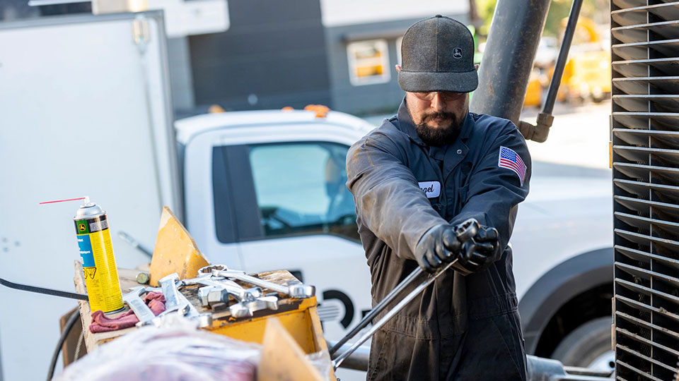 service technician using wrench on machine