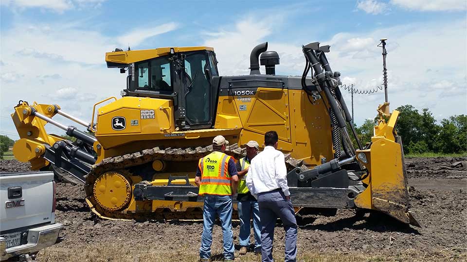 two technicians working on equipment in field