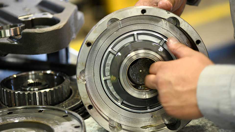 mechanic handling machine parts on workbench