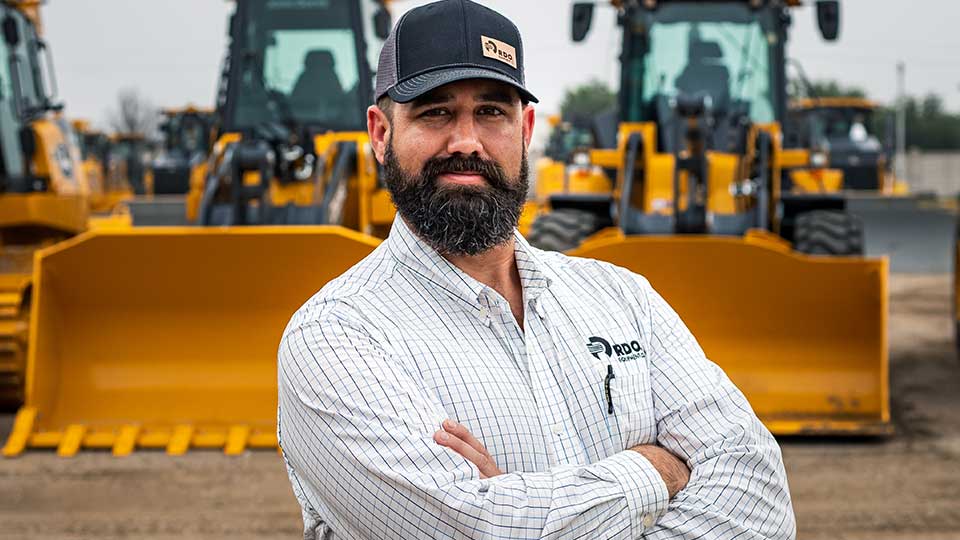 Service manager arms folded in front of machinery