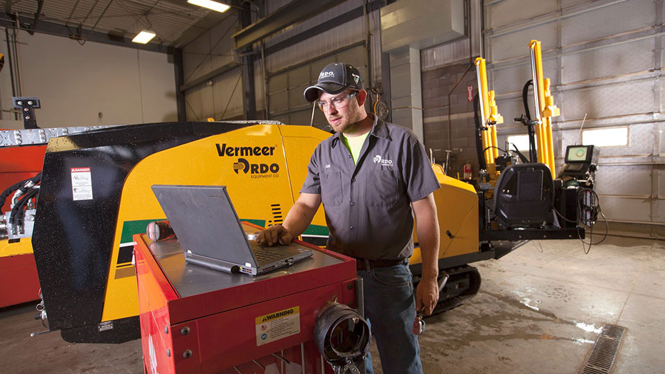 Mechanic in service shop working on vermeer machinery