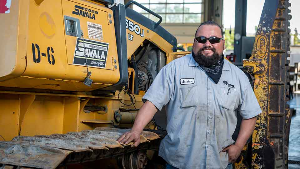 service technician standing next to machine hand on track