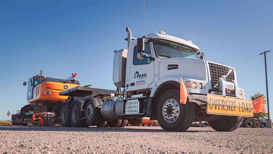Heavy Haul Semi Truck loaded with John Deere Machine