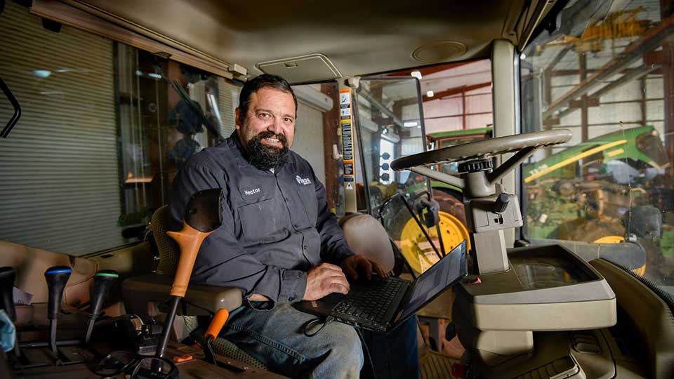 service technician sitting in cab of tractor