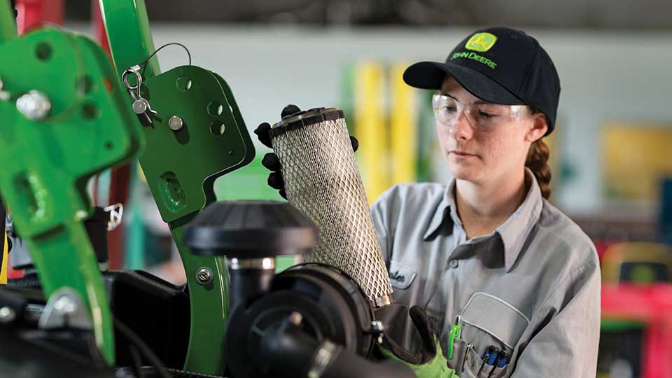 service technician replacing filter in machine