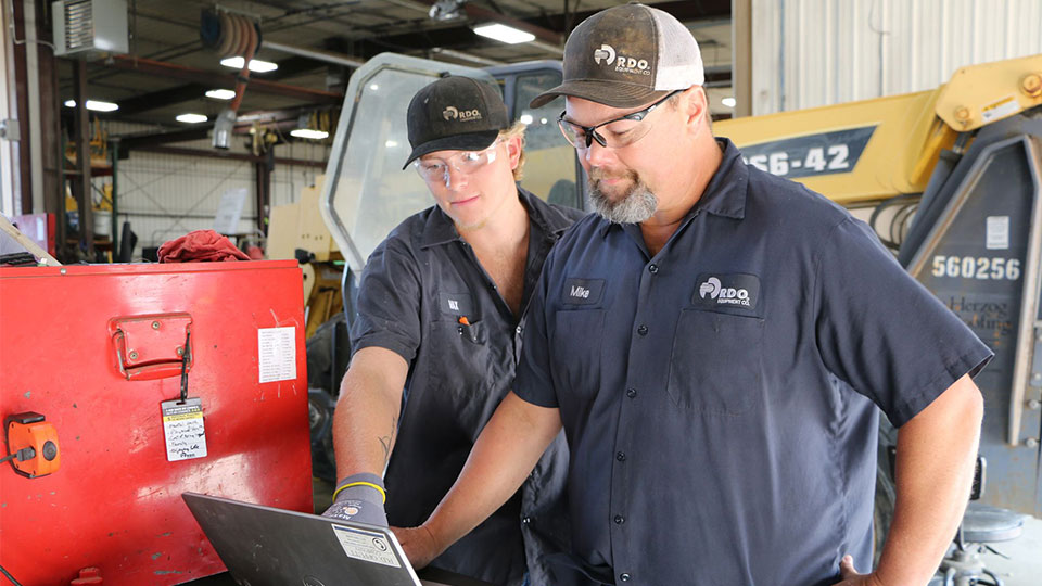 service technicians looking at screen in shop