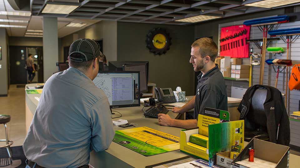 parts specialist at counter helping customer