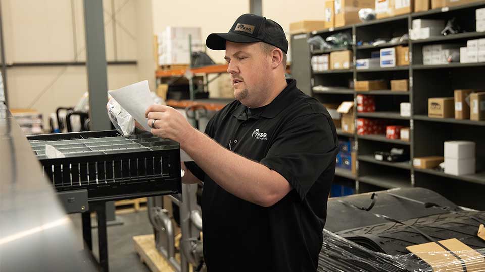 parts specialist reading parts order in warehouse