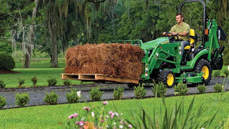 person using 2025R to move hay