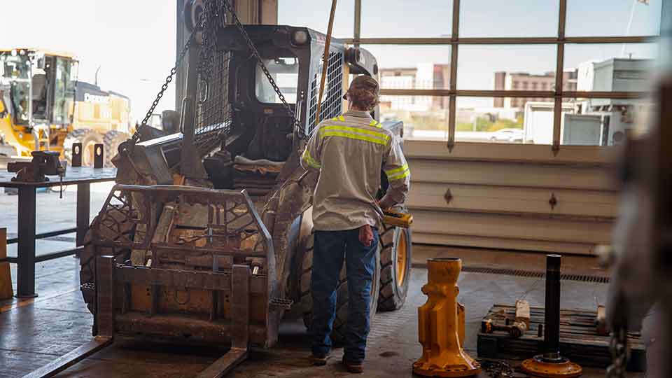 Service technician working on a forklift in shop