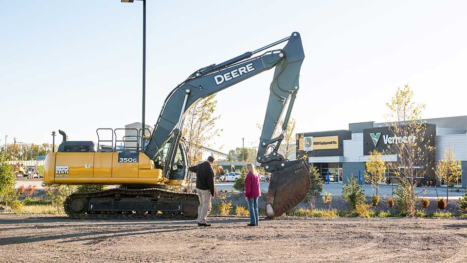 Sales Professional in front of John Deere Construction Equipment