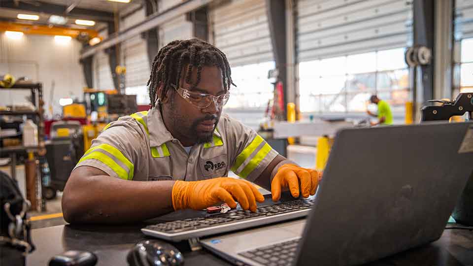 Service technician using laptop in service shop