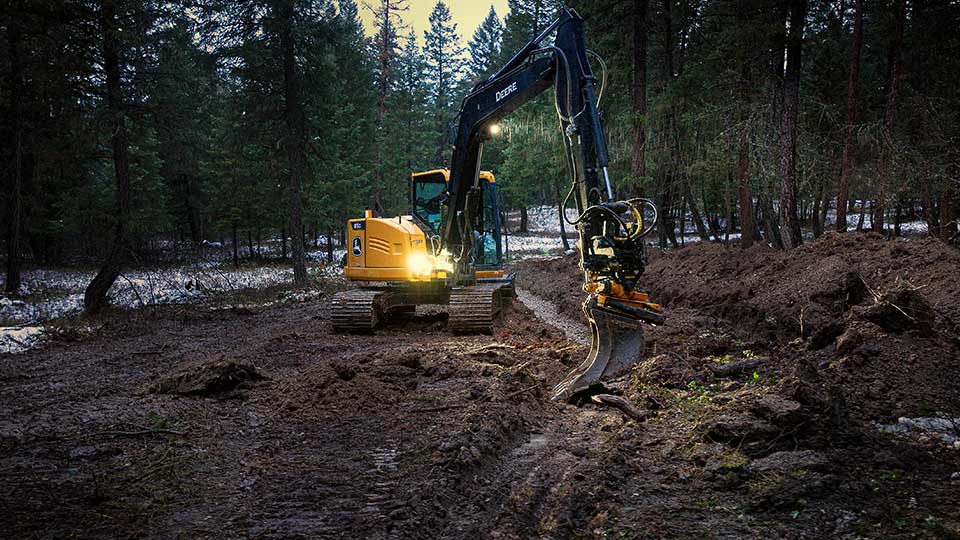 john deere construction equipment in forest