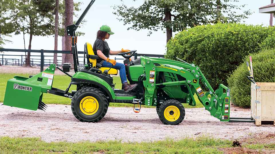 Woman moving box with q series compact utility tractor